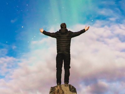 Young man with arms raised to the night sky